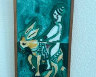 mid-century modernist ceramic tile artwork depicting a stylized figure riding a donkey.