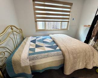 Brass bed, beautiful bedding, and clothes