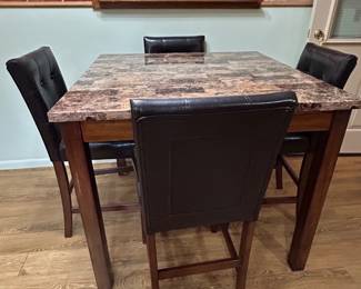 counter-height dining set featuring a faux marble tabletop and black vinyl-upholstered bar stools
