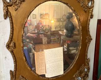Ornate gilt oval mirror
