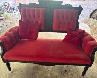 1870s Victorian Eastlake settee with a walnut frame and bright red upholstery with two pillows that match