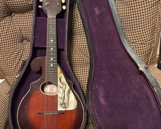 According to Google this is a 1920s Reverse Scroll Flatback Mandolin. It was manufactured by the Regal Musical Instrument Company based in Chicago, Illinois. Comes with the original case! 