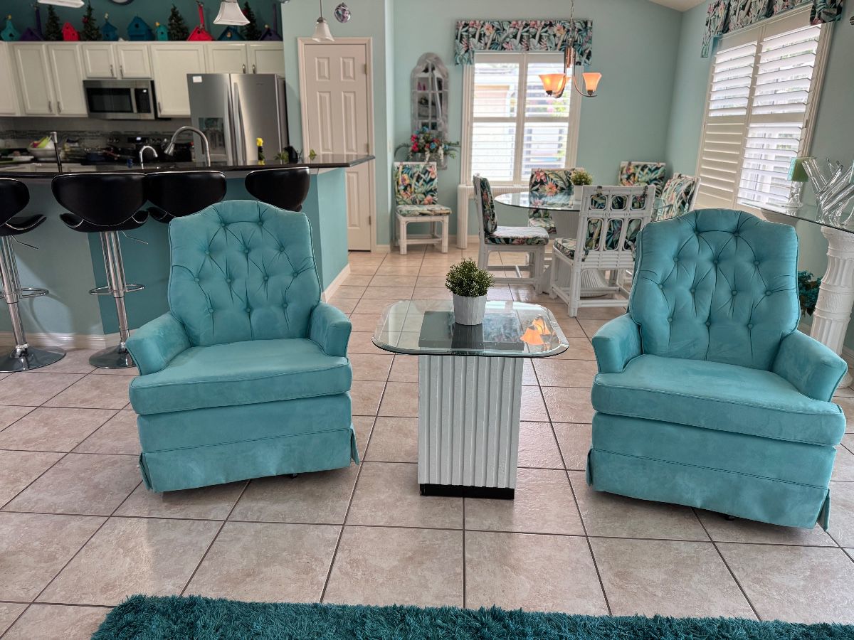 Beautiful pair of aqua tufted swivel accent chairs with plush seating and classic button-tufted backs. A perfect addition to a living room, reading nook, bedroom, or Florida home with coastal-inspired décor.