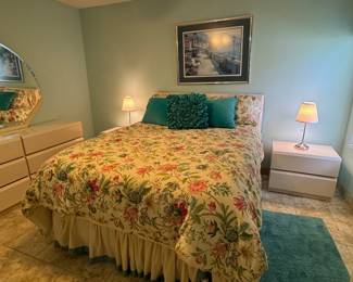 Contemporary gloss ivory bedroom collection featuring a dresser with coordinating geometric mirror, two nightstands, and matching bed. Elegant modern styling with a warm ivory finish and clean architectural lines, perfect for a guest room or primary suite. AQueen