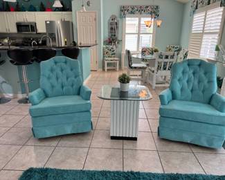 Beautiful pair of aqua tufted swivel accent chairs with plush seating and classic button-tufted backs. A perfect addition to a living room, reading nook, bedroom, or Florida home with coastal-inspired décor.