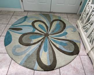 Contemporary round area rug featuring soothing coastal tones of aqua, beige, gray, and brown. A beautiful accent for a living room, dining area, or sunroom.