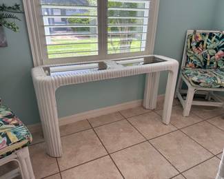 Stylish white rattan console table featuring two inset glass panels. A versatile coastal-inspired accent, perfect for an entryway, hallway, sunroom, or behind a sofa.