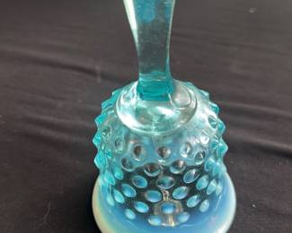 Fenton Blue Opalescent Hobnail Bell — This charming Fenton blue opalescent hobnail glass bell adds a vintage decorative touch to any collection. Made from opalescent glass with a textured hobnail pattern, its glossy cobalt blue fades to milky white at the base, measuring approximately 5 inches tall. The piece is in good condition with no chips or cracks visible, showcasing classic mid-20th century American glass craftsmanship. Ideal as a collectible or elegant accent piece for shelves and display cabinets.