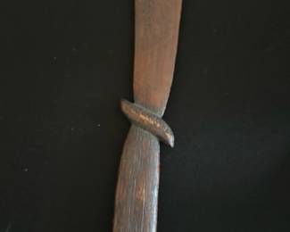 Carved Wooden 1903 — This carved wooden letter opener features a rustic textured handle and a unique blade shape, with the year "1903" and decorative carvings etched into the blade. Crafted from a dark-stained wood, it offers a vintage charm suitable for display or practical use. Measuring approximately 10 inches in length, this piece is lightweight and easy to handle. The letter opener shows signs of age with minor surface wear but remains in good condition overall. A distinctive collectible item likely dating back to the early 20th century.