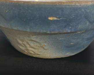 Antique Blue Glazed Ceramic Bowl — This antique blue glazed ceramic bowl features a rustic design with a crackled cream interior and a textured swirl pattern on the base. The bowl displays subtle signs of wear and age, consistent with vintage ceramic craftsmanship. Measuring approximately 3.25 inches in height and 8 inches in diameter, it is a modestly sized decorative or functional piece. The bowl is in fair condition with minor chipping and surface imperfections typical for an item of its age. This piece would be a charming addition to any vintage or collectible ceramic collection.