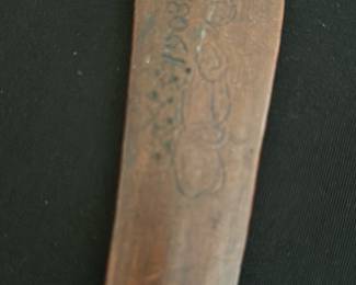 Carved Wooden 1903 — This carved wooden letter opener features a rustic textured handle and a unique blade shape, with the year "1903" and decorative carvings etched into the blade. Crafted from a dark-stained wood, it offers a vintage charm suitable for display or practical use. Measuring approximately 10 inches in length, this piece is lightweight and easy to handle. The letter opener shows signs of age with minor surface wear but remains in good condition overall. A distinctive collectible item likely dating back to the early 20th century.