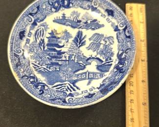 Blue Willow saucer — This charming Semi China plate features the classic blue and white Willow pattern, a beloved design with pagodas, bridges, and willow trees. Crafted from fine china with a detailed border, this plate measures 8.5 inches in diameter, ideal for collectors or as decorative dishware. It is in good condition with minor surface wear typical for its age. The backstamp indicates it was made for A.W. Hewison & Son Ltd., England, dating this piece as an authentic collectible. Perfect for vintage dishware collections or as a nostalgic accent piece.