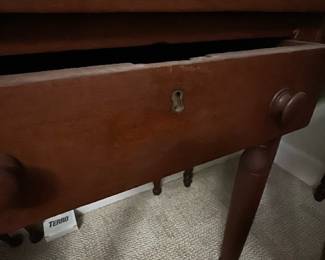 Antique Mahogany Side Table — This antique mahogany side table features a classic design with turned legs and a single drawer with wooden knobs and a keyhole. The rich mahogany finish highlights the traditional craftsmanship and versatile style, suitable for a bedroom or living space. It measures approximately 29 inches in height, 24 inches in width, and 18 inches in length, making it a compact yet functional piece. The table shows some minor surface wear consistent with age but remains sturdy and well-maintained. An elegant example of timeless furniture that complements various decor styles.