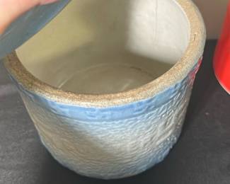 Blue Crock butter Covered Jar — This blue ceramic covered jar features a textured surface and a snug fitting lid with a small knob handle. The jar showcases a gradient blue glaze that fades from a deeper blue at the rim to a pale finish toward the base, giving it a charming handcrafted appearance. Measuring approximately 4 inches in height and 4.5 inches in diameter, it is suitable for decorative storage or accent display in the bonus up room. The piece is in good condition with no visible chips or cracks and retains its original glaze and structure. Its simple yet rustic design makes it a versatile home decor piece.