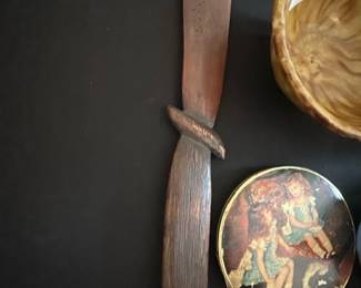 Carved Wooden 1903 — This carved wooden letter opener features a rustic textured handle and a unique blade shape, with the year "1903" and decorative carvings etched into the blade. Crafted from a dark-stained wood, it offers a vintage charm suitable for display or practical use. Measuring approximately 10 inches in length, this piece is lightweight and easy to handle. The letter opener shows signs of age with minor surface wear but remains in good condition overall. A distinctive collectible item likely dating back to the early 20th century.