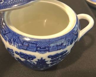 Allertons Ltd Blue Willow Sugar Bowl — This charming sugar bowl features the classic Allertons Ltd English Blue Willow pattern with its iconic blue and white design. Crafted from fine porcelain, it includes a fitted lid and dual handles for ease of use. Measuring approximately 3.5 inches in height and 5 inches wide including handles, it is a perfect addition to any tea or dining set. The piece is in good condition with mild wear consistent with age and no visible chips or cracks. Marked on the bottom with the Allertons Ltd maker's stamp and 'Made in England' designation, this bowl represents fine English china craftsmanship.