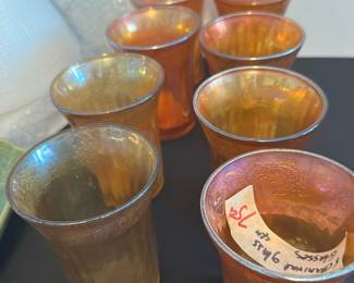 Carnival Glass Set of 8 — This charming set of eight carnival glasses features a vibrant iridescent finish with an embossed pattern throughout. Each glass measures approximately 4 inches in height, ideal for decorative use or serving small beverages. The glasses are in good condition with minor surface wear consistent with age, adding to their vintage appeal. These carnival glasses showcase classic pressed glass craftsmanship, making them a lovely addition to any collection or display. Perfect for collectors or those looking for unique vintage barware.