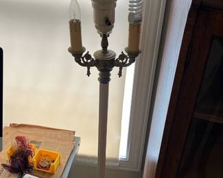 Vintage White Floor Lamp — This vintage floor lamp features a tall white base with intricate detailing near the bottom and three arms for bulbs, including candle-style holders. It has a white ribbed glass top shade that diffuses light softly, perfect for an office or living area. The lamp stands approximately 59 inches tall and has an estimated weight of 12 pounds, making it a sturdy but portable lighting fixture. Condition is good with some typical wear and minimal discoloration consistent with age. A classic piece blending functional lighting with elegant vintage design, ideal for traditional or eclectic decor.