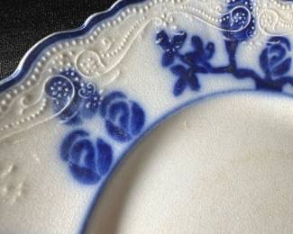 W.A.adams England blue lunch plate — This Wood & Sons Flow Blue plate from England features a beautiful deep blue floral design around a scalloped edge on white porcelain. The plate measures approximately 9 3/8 inches in diameter and shows fine crazing consistent with age, adding vintage charm. It is a classic example of Flow Blue transferware, a collectible style popular in the late 19th and early 20th centuries. The plate is in good condition with no visible chips or cracks, perfect for display or light use. A true piece of English ceramic heritage with a distinctive blue-on-white pattern.