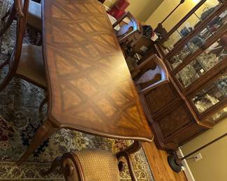 Dining Room Wood Inlaid Table & chairs — This elegant dining room table features a finely crafted wood surface with intricate inlaid diamond patterns. The table is supported by sturdy cabriole legs and comes with matching upholstered armchairs in a beige diamond pattern fabric. Measuring approximately 31 inches in height, 42 inches in width, and 90 inches in length, it offers ample seating for family and guests. The piece is in good condition with minor surface scratches consistent with normal use. Its classic design and quality woodwork make it a versatile addition to any traditional dining space.