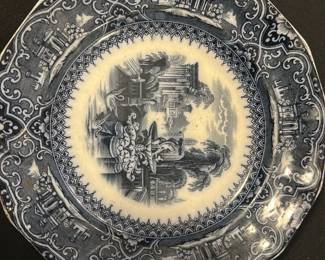 Adams & Sons Blue Athens Plate — This charming Adams & Sons blue plate features a detailed classical scene with architectural elements evocative of Athens. The plate is decorated in a deep blue transferware pattern with ornate borders and scenic central imagery. Measuring approximately 9.25 inches in diameter, it is crafted from fine ceramic with a glazed finish that shows typical age-related crazing. The plate is in good condition with no visible chips or cracks, showcasing its collectible transferware appeal. The maker's mark and pattern number confirm its authenticity as an Adams & Sons design, popular among collectors of historical ceramics.