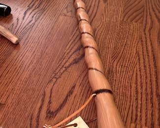 Tennessee Hickory Wood Walking Stick — This handcrafted walking stick is made from Tennessee hickory wood by Tennessee Craftsman. It features a unique twisted design along the length, enhancing grip and aesthetics. Measuring approximately 30 inches in length, the stick is sturdy and suitable for outdoor hiking use. The wood is in excellent condition with a smooth finish and no visible damage. This piece represents traditional Tennessee craftsmanship, perfect for collectors or hikers seeking durable gear.