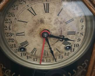 Antique Carved Oak Mantel Clock — This antique carved oak mantel clock features intricate woodwork with ornate floral and geometric patterns surrounding a glass face. The dial displays Roman numerals alongside a 31-day calendar, adding both stylistic charm and functionality. Measuring approximately 14 inches tall, 10 inches wide, and 4 inches deep, it is a decorative timepiece ideal for traditional home decor. The clock shows signs of age including patina and slight discoloration on the dial but remains an attractive vintage collectible. Perfect for collectors of antique clocks or those looking to enhance a vintage-styled bedroom space.
