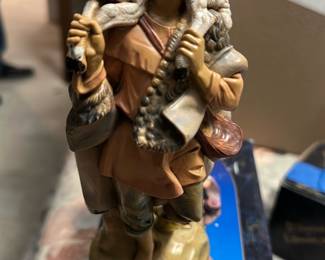 Fontanini Gabriel 7.5" Figure — This Fontanini 'Gabriel' 7.5" resin/painted figure from the Fontanini Heirloom Collection (Roman, Inc.) depicts a shepherd boy carrying a lamb and is presented with its original box. Hand-painted details show warm flesh tones, soft pastels on the clothing, and textured lamb fur for a classic Nativity/collectible look. Figure measures approximately 7.5 inches tall and is a small, shelf-ready decorative piece perfect for holiday displays or collector shelves. In good condition overall with light shelf wear to the box and minor surface wear to the paint consistent with age; no obvious chips or breaks visible in photos.