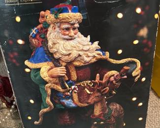 Holiday Expressions 15" Santa — This Holiday Expressions 15" hand-painted Old World Santa decoration is a festive collectible holiday figure. It appears to be a resin or polystone Santa with detailed paint, carrying gifts and a small reindeer at his feet, packaged in the original printed box. Box shows heavy wear and tape repairs; figure condition inside unknown but likely good if stored carefully — pictured box is worn. Great for seasonal mantle or tabletop display and ideal for estate-sale buyers seeking classic Old World holiday decor.