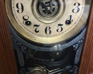 Vintage Oak Mantel Clock with Carved Det — This vintage oak mantel clock features intricate carved leaf and floral designs on the frame, highlighting fine craftsmanship. The clock face has a cream dial with black Arabic numerals and visible brass clockwork through the glass door. The detailed pendulum and etched glass panel add to the clock’s ornate Victorian-style charm. Measuring approximately 16 inches tall by 10 inches wide, it is a striking decorative and functional piece. It is in good condition with minor wear consistent with age and appears to be fully intact but unverified for working condition.