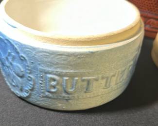 Blue Ceramic Butter Dish Crock — This blue ceramic butter dish crock features a traditional design embossed with the word 'BUTTER' and decorative accents. It measures approximately 3.5 inches in height and 6 inches in width, making it a practical and charming addition to kitchenware. The piece is in good condition, with some typical wear consistent with vintage ceramic items. Though the seller notes this is not a lid butter crock, it serves well as a decorative butter container or kitchen accessory. Its classic style and blue color make it suitable for farmhouse or country-style decor.