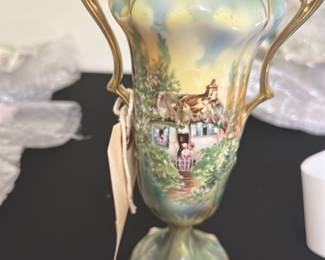 RS Prussia 8in Hand-Painted Vase — This exquisite RS Prussia vase features a delicate hand-painted pastoral scene with a thatched cottage and garden, accented by ornate gold handles and trim. The vase displays a soft blend of pastel greens and blues, enhancing its vintage charm and collectible appeal. Measuring 8 inches tall, this elegant piece is perfect for display in a bonus up room or any refined setting. It is in excellent condition with no visible chips or cracks and retains its original vibrant finish. RS Prussia pieces are renowned for their craftsmanship and artistry from the late 19th to early 20th century.