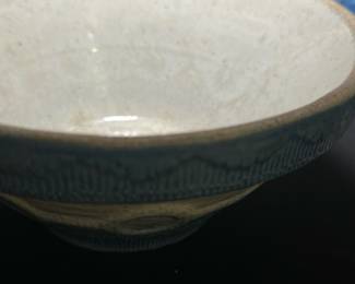 Blue Patterned Pottery Bowl — This blue-patterned pottery bowl features a textured design with circular and linear motifs along the exterior rim and body. The bowl has a cream-colored interior and subtle rustic detailing on the base. Measuring approximately 3.5 inches tall and 7.5 inches in diameter, it is a charming decorative or functional piece. There is a visible chip on the rim and some wear on the base consistent with age and use, adding character to the bowl. Its handmade look and glaze suggest a vintage or artisan origin, suitable for collectors or casual display.