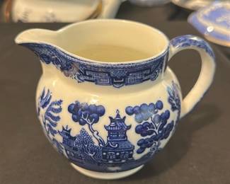 Allertons Blue Willow Creamer Pitcher — This charming Allertons creamer pitcher features the iconic blue willow pattern, a classic English design. Crafted from fine china, it showcases detailed scenic motifs in cobalt blue against a white background, embodying traditional craftsmanship from England. The creamer measures approximately 3.5 inches in height and 5 inches in width, perfect for serving cream or milk at the table. It is in good condition with no visible chips or cracks, maintaining its vintage appeal. Marked with the Allertons hallmark and 'Made in England,' this piece is a delightful collectible for lovers of classic English china.