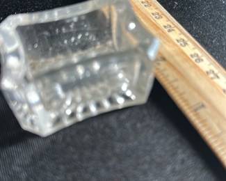 Clear Glass Salt Cellar Dish — This clear glass salt cellar dish features a classic rectangular shape with scalloped sides and a textured starburst pattern on the base. Crafted from thick clear glass, it provides an elegant and functional table accessory. Measuring approximately 2.5 inches wide, 1.5 inches high, and 2.5 inches deep, this small dish is ideal for holding salt or spices during meals. The item is in good vintage condition with minor surface wear typical for its age. A charming addition for collectors or those seeking vintage dining accessories.