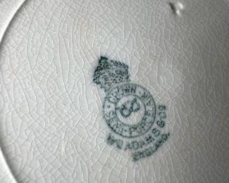 W.A.adams England blue lunch plate — This Wood & Sons Flow Blue plate from England features a beautiful deep blue floral design around a scalloped edge on white porcelain. The plate measures approximately 9 3/8 inches in diameter and shows fine crazing consistent with age, adding vintage charm. It is a classic example of Flow Blue transferware, a collectible style popular in the late 19th and early 20th centuries. The plate is in good condition with no visible chips or cracks, perfect for display or light use. A true piece of English ceramic heritage with a distinctive blue-on-white pattern.
