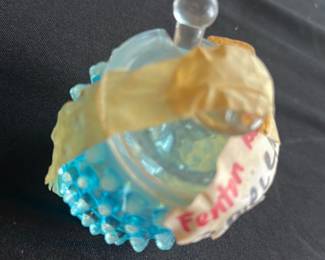 Fenton Blue Hobnail Glass Jar — This charming Fenton blue hobnail glass jar features a hobnail texture classic to Fenton's collectible glassware. The jar includes a clear round stopper and retains a vintage appeal with its textured pattern and delicate design. It measures approximately 2.5 inches in height and width, making it a compact decorative accent perfect for display or small storage. Condition is good with minor surface wear consistent with vintage usage; original labels and tape remain on the item. An appealing collectible for fans of Fenton and hobnail glassware, great for master bedroom decor or gift collectors.