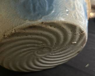 Antique Blue Glazed Ceramic Bowl — This antique blue glazed ceramic bowl features a rustic design with a crackled cream interior and a textured swirl pattern on the base. The bowl displays subtle signs of wear and age, consistent with vintage ceramic craftsmanship. Measuring approximately 3.25 inches in height and 8 inches in diameter, it is a modestly sized decorative or functional piece. The bowl is in fair condition with minor chipping and surface imperfections typical for an item of its age. This piece would be a charming addition to any vintage or collectible ceramic collection.