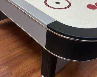 Harvard Air Hockey Table — This Harvard air hockey table combines classic arcade fun with durable construction and a sleek design. It features a white play surface with red and black markings, including the Harvard logo and name prominently displayed on both ends and center ice. The table measures approximately 84 inches in length, 42 inches in width, and 30 inches in height, making it suitable for home game rooms or recreational spaces. In good condition, it shows minor signs of use with clean playing surface and intact legs providing sturdy support. Ideal for entertaining family and friends in a basement or game room setting.