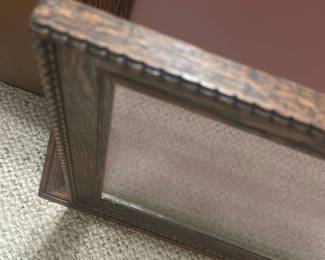 Antique shadow box frame — Attractive wood-grain decorative picture frame with textured carved edging and a dusty rose backing board. The frame appears to be constructed from molded wood or oak-look composite with a glass front and hanging chain on the back. Overall size is moderate and suitable for tabletop or wall display; lightweight and easy to hang. Frame shows light wear to finish and a small tear in the backing paper but glass and molding are intact.