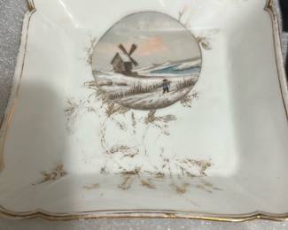 12-CF Thai Porcelain Small Square Dishes — This set of 12 small square porcelain dishes from Thailand features delicate landscape paintings with subtle gold accents around the scalloped edges. Each dish measures approximately 5.5 in by 5.5 in, ideal for serving small items or decorative display. The white porcelain is complemented by fine, hand-painted scenic details and light gold foliage. These dishes are in good condition with minor signs of age or use, perfect for collectors or elegant tabletop settings. The craftsmanship reflects traditional Thai porcelain art, making them unique collectible pieces.