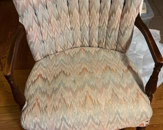 Upholstered Accent Armchair — Comfortable upholstered accent armchair with carved wooden arms and fluted legs, ideal for a master bedroom seating area. The fabric shows a muted pastel ikat-like pattern in the seller-provided colors and the piece features channel-tufted back detailing and brass nailhead trim at the seat corners. Measurements are provided for planning: overall size fits well in a bedroom or living room and it's light enough to move for cleaning or staging. Chair is in good condition with minor wear to fabric and light surface scuffs on wood consistent with normal use.