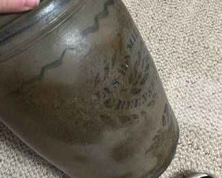 Hamilton Co. Stoneware Crock Jar — This antique Hamilton Co. stoneware crock jar features a classic cylindrical shape with a wide mouth and a hand-painted decorative blue design including the maker's mark 'J & L Hamilton Co., Greensboro, PA'. The crock measures approximately 8.5 inches in height and 5 inches in diameter, constructed from durable gray salt-glazed stoneware typical of 19th-century craftsmanship. It is in good condition with some surface wear and patina consistent with age, adding to its vintage charm. This piece is a desirable collectible for those interested in early American stoneware pottery and historical kitchenware.