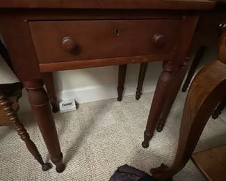 Antique Mahogany Side Table — This antique mahogany side table features a classic design with turned legs and a single drawer with wooden knobs and a keyhole. The rich mahogany finish highlights the traditional craftsmanship and versatile style, suitable for a bedroom or living space. It measures approximately 29 inches in height, 24 inches in width, and 18 inches in length, making it a compact yet functional piece. The table shows some minor surface wear consistent with age but remains sturdy and well-maintained. An elegant example of timeless furniture that complements various decor styles.