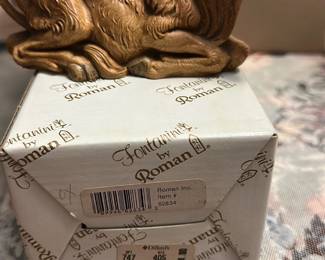 Fontanini Roman Nativity Ox — This Fontanini by Roman nativity ox figure is a detailed resin/painted piece from the popular Fontanini nativity line. The figure is painted a warm brown with textured fur detailing and lifelike eyes; it comes with the original Fontanini by Roman box labeled item #52834 and a Dillard's price sticker. Measuring approximately 4.5 inches tall, 8.5 inches long and 3.5 inches deep, it's a compact, display-ready piece for holiday scenes or shelf decor. Overall in good condition with light shelf wear to paint consistent with normal display; box shows retail stickers and light age wear.