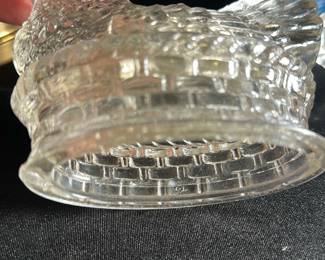 Clear Glass Hen — This clear glass hen covered dish features detailed textured patterns resembling feathers and a woven basket base. The hen serves as a removable lid, revealing a practical storage bowl beneath. Measuring approximately 4.5 inches tall, 7 inches wide, and 5 inches deep, this vintage collectible is perfect for decorative display or practical use. The dish is in good condition with no visible chips or cracks. A classic piece often used in kitchens or dining areas, adding vintage charm to your home.