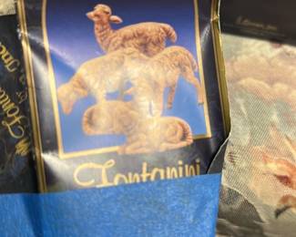Fontanini The Sheep Nativity Set — Fontanini 'The Sheep' nativity figures in dark blue packaging from the Blue Dishes Room. The box shows multiple resin or composite sheep figurines pictured on the front and is likely part of a Fontanini nativity collection; packaging is creased and taped as shown. Overall box measures approximately 8.5 in height, 5.5 in width and 2.5 in depth (est.), containing small collectible figures suitable for tabletop nativity displays. Condition: box shows wear, creasing and tape but figurines inside are presumed complete though not verified; sold as-is for estate sale.