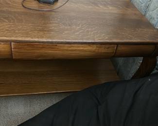 Oak Wood Queen Anne Style Table — This elegant oak wood table features Queen Anne style cabriole legs with claw feet, offering a classic and refined look. The rich wood grain is visible throughout, complemented by a smooth rectangular top and a functional lower shelf for additional storage or display. The piece includes a small drawer with dovetail joints, enhancing both utility and craftsmanship. It measures approximately 24 inches high, 26 inches wide, and 18 inches deep, making it suitable for bedroom or living room use. The table is in good condition with typical light surface wear and minor scratches consistent with age and use.