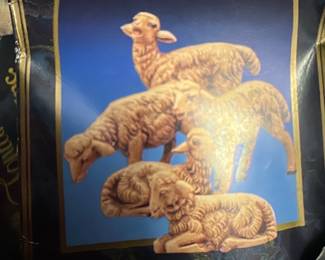 Fontanini The Sheep Nativity Set — Fontanini 'The Sheep' nativity figures in dark blue packaging from the Blue Dishes Room. The box shows multiple resin or composite sheep figurines pictured on the front and is likely part of a Fontanini nativity collection; packaging is creased and taped as shown. Overall box measures approximately 8.5 in height, 5.5 in width and 2.5 in depth (est.), containing small collectible figures suitable for tabletop nativity displays. Condition: box shows wear, creasing and tape but figurines inside are presumed complete though not verified; sold as-is for estate sale.