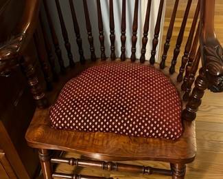 Mahogany Spindle Back Accent Chair — Mahogany spindle-back accent chair with carved arms and a removable red patterned seat cushion. Solid wood construction with turned spindles, carved arm terminals and stretchered legs; cushion fabric is a red diamond-patterned upholstery. Estimated measurements provided for practical reference; chair is sturdy and shows light surface wear and minor scuffs consistent with normal use. Good overall condition with no visible structural damage; cushion shows slight flattening from use.